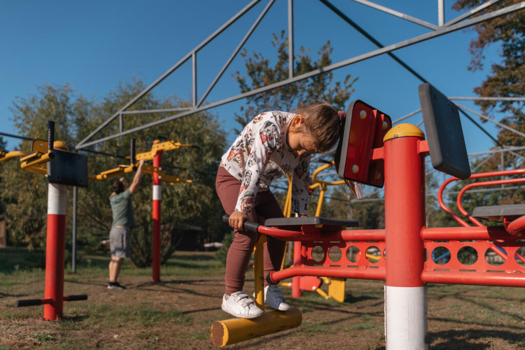 Outdoor play equipment with slides, swings, and climbing frames in a school playground.